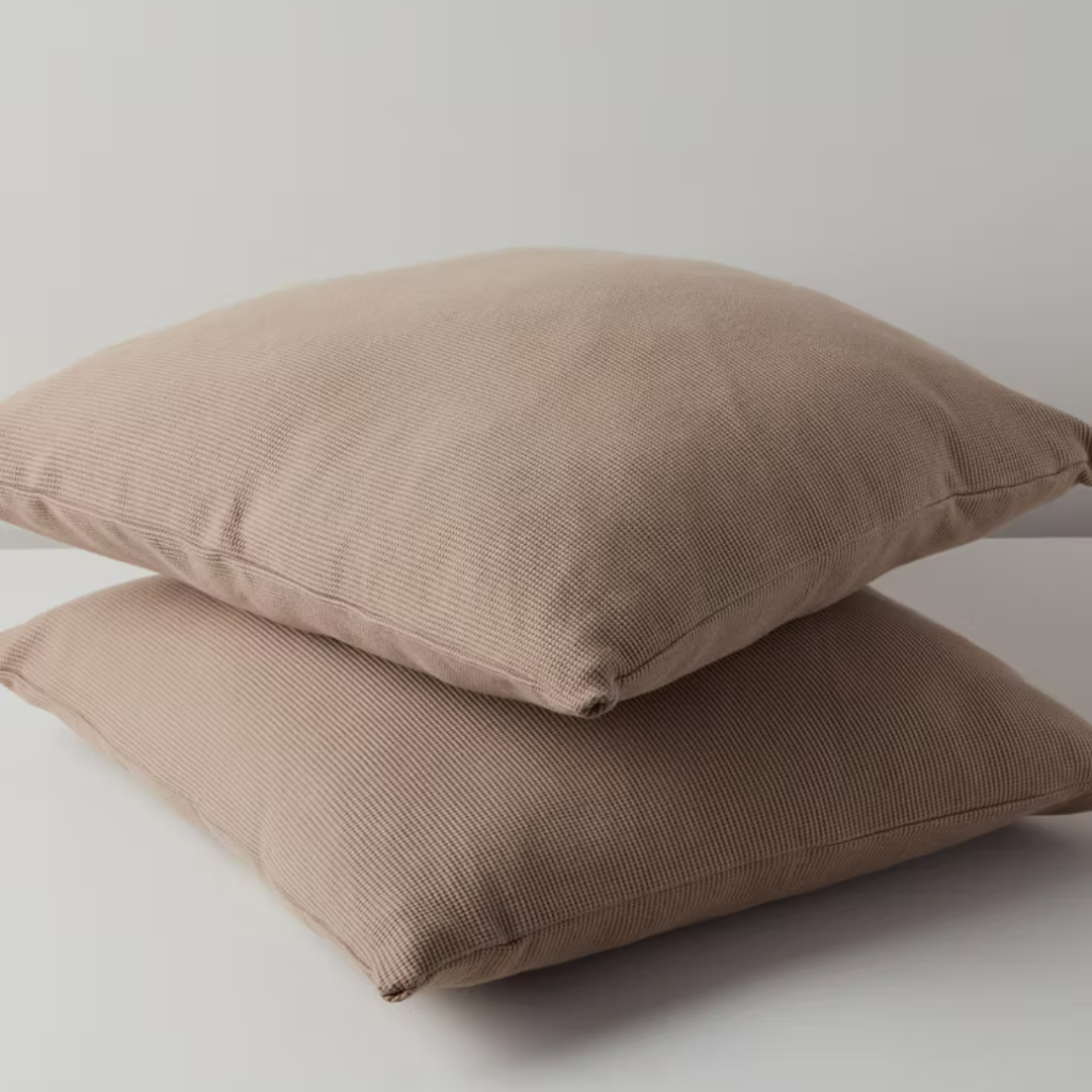 כריות נוי וופל מכותנה אורגנית מסודרות בשורה בצבעחום שוקו.