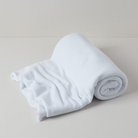 תקריב של טקסטורת וופל על שמיכת כותנה אורגנית בצבע לבן שלג