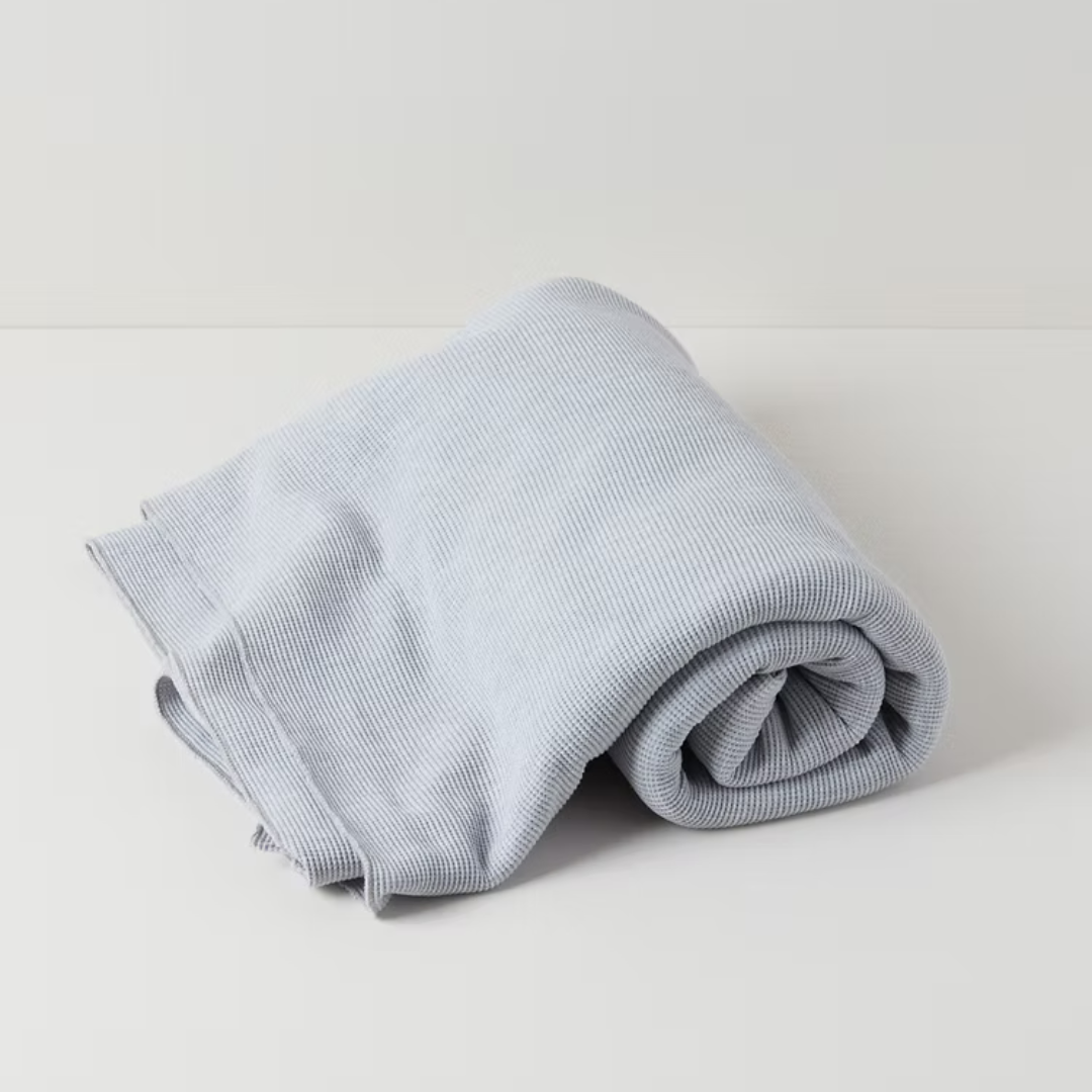 תקריב של טקסטורת וופל על שמיכת כותנה אורגנית בצבע אפור מלאנג