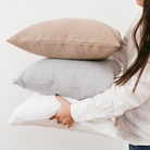  כריות נוי וופל מכותנה אורגנית מסודרות בשורה, ומציגות את צבעי הקולקציה: לבן שלג, אפור מלאנג' וחום שוקו.