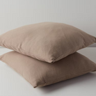  כריות נוי וופל מכותנה אורגנית מסודרות בשורה בצבעחום שוקו.